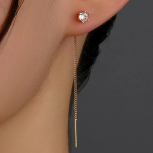 Detail of elegant gold tassel earrings with six-claw round zircon inlay on a model