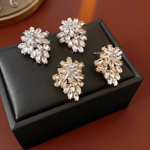 Detail of floral and leaf stud earrings with crystals in gold and silver finishes