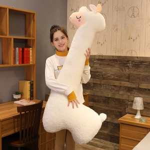 Detail of a large white alpaca plush pillow showing soft sherpa texture in a home setting