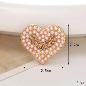 Macro shot of 2.5cm heart shoe charm with white pearls and amber crystal inlay