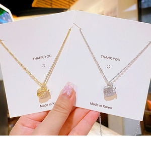 Detail of swan necklaces in gold and silver with cubic zirconia on jewelry cards