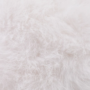 Close-up of soft white rabbit fur texture on the winter baseball cap with plush long fibers