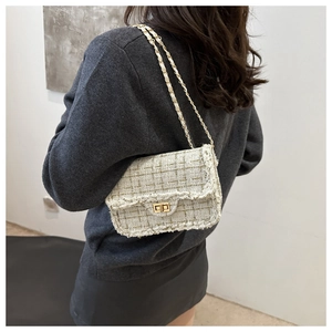 Side view of beige tweed chain bag on model showing shoulder strap and weaving detail