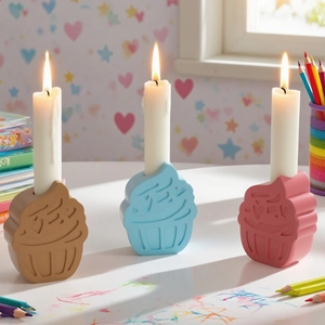 Three colorful cupcake candle holders in blue, pink and brown with lit white candles