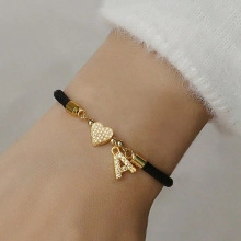 Detail of gold beaded bracelet with micro-pave heart and letter A charm on wrist