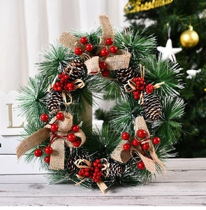 Detalle de corona de Navidad artesanal con bayas rojas y pino con efecto nieve