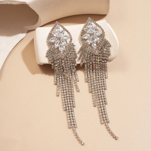 Close-up of sparkling silver tassel earrings with geometric flower and zircon details