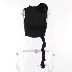 Detail of a black cropped top featuring a large 3D floral accent and cascading ruffles