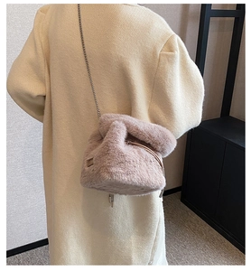 Pink plush bucket bag with metal chain strap worn by a model in a beige coat
