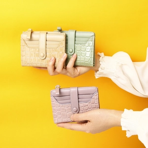 Three elegant crocodile pattern leather wallets in beige, light green, and light purple colors