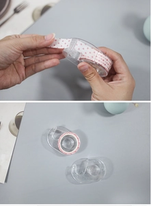 Macro view of transparent acrylic tape dispenser with pink polka dot washi tape roll