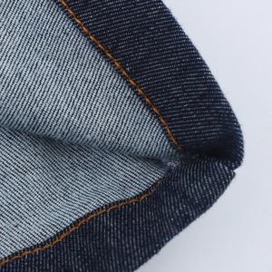 Vue macro détaillée de la texture denim bleu foncé et des coutures orange contrastées