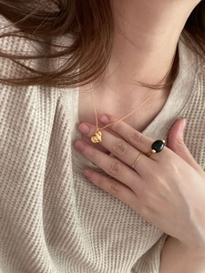Minimalist gold heart necklace and rings set worn over beige knit sweater for women