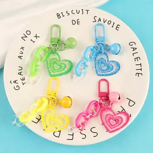 Colorful acrylic heart keychains with bells and chains in various candy colors