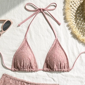 Detail of pink floral lace bikini set with halter ties and textured crochet fabric