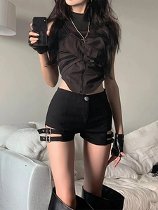 Dettaglio di pantaloncini punk neri a vita alta con fibbie in metallo e design cut-out