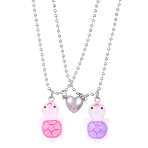 Detail of pink and purple turtle couple necklaces with magnetic heart connection