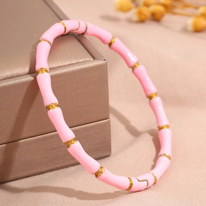 Detail eines pinkfarbenen Emaille-Gold-Bambusarmreifs auf einer Luxus-Schmuckschatulle