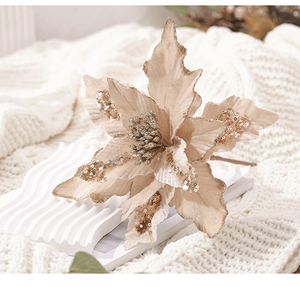 Détail d'une fleur de Noël en velours champagne avec paillettes d'or sur tricot