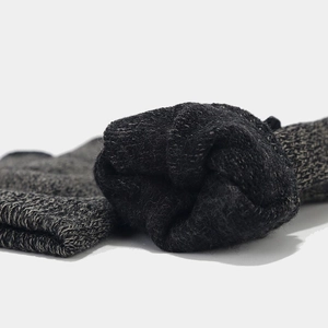 Close-up of dark grey thick knit fabric texture showing warmth and detailed material