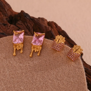 Macro detail of gold earrings with pink zircon stones and fries-shaped diamond studs