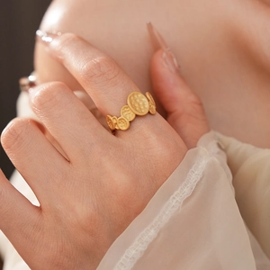Close-up of a vintage-style gold ring with overlapping oval discs and hammered texture