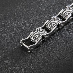 Macro view of vintage silver floral engraved links on a stainless steel men's bracelet
