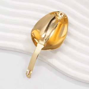 Close-up of golden irregular liquid metal hair clip with a secure pressure snap mechanism