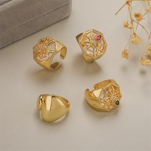 Set di quattro anelli ragnatela dorati con pietre di zircone su sfondo grigio