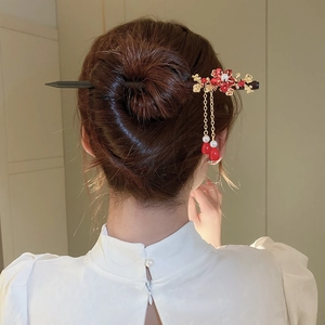 Detail of wooden hair stick with red flowers and pearls in traditional style