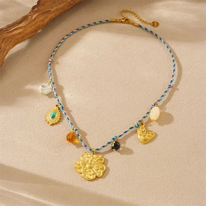 Detail of woven rope necklace featuring a gold flower pendant and turquoise stone accents