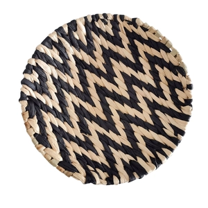 Dettaglio decorazione murale in erba intrecciata con motivi a zigzag neri e beige