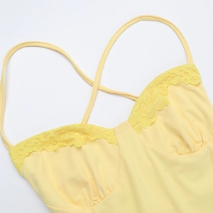 Détail de la robe dos nu jaune avec bordure en dentelle et fines bretelles croisées