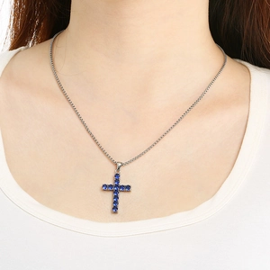 Hip hop silver chain necklace featuring a stunning blue rhinestone cross pendant on model