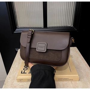 Detailed view of dark brown crossbody bag with leather and suede texture contrast