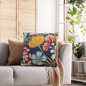 Floral embroidery pillow case in navy blue on a sofa in a cozy bright living room