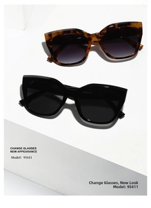 Detailed view of tortoiseshell and black cat-eye sunglasses on geometric white props