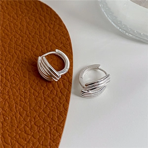 Macro shot of silver multi-layer ear cuff on leather surface showing S925 sterling silver mark