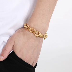 Macro shot of men's chunky golden rope chain bracelet with detailed engraved clasp