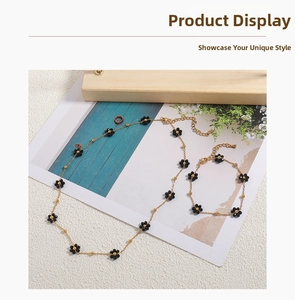 Detail of 18K gold plated titanium steel necklace with black daisy floral elements