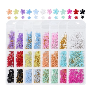 Detailed view of colorful 5-petal resin flowers and beads for DIY nail art and crafts