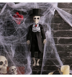 Groom skeleton decoration in black tuxedo hanging in spooky spider web scene