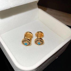 Detail von 18K vergoldeten Sonnenohrringen mit Türkis und Zirkon in einer Geschenkbox