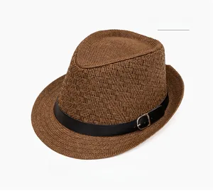 Detail of coffee straw fedora featuring a woven texture and black leather band with buckle