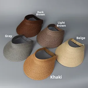 Flat lay of raffia sun visors in five colors including khaki and beige on grey background