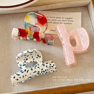 Three acetate hair claws with marble and floral patterns in a vintage French style