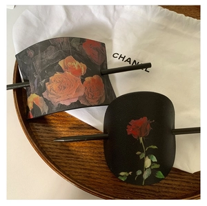 Vue détaillée d'épingles à cheveux en cuir vintage avec imprimés de roses rouges