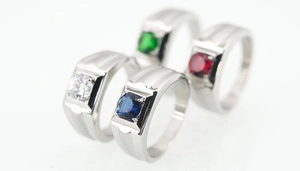 Close-up of multicolor square gemstones in silver stainless steel rings for couples