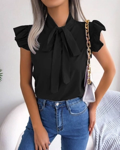 Detail of black sleeveless chiffon shirt featuring a bow neckline and ruffle sleeve trim