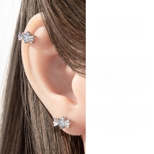 Dettaglio dell'orecchino a fiocco in argento con zircone azzurro sulla cartilagine